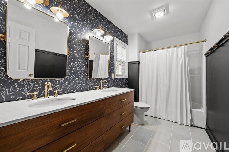 A bathroom with a black and white patterned wallpaper and a black refrigerator.
