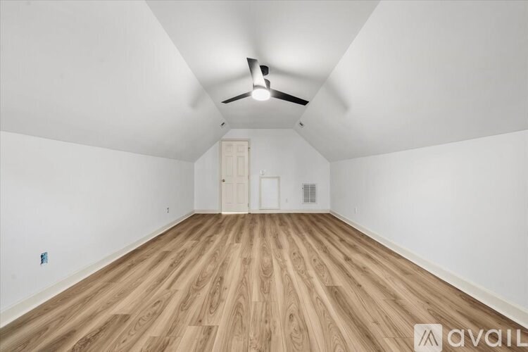 A room with wooden flooring and a ceiling fan.