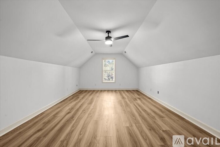 A room with wooden flooring and a ceiling fan.