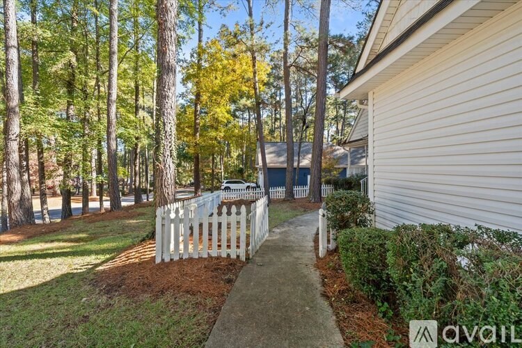 A house with a white picket fence and a tree with yellow leaves.