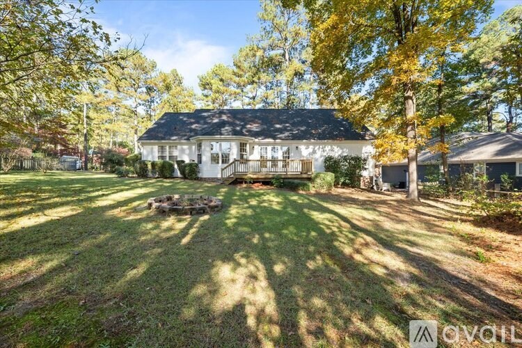 A house with a lawn and trees in the background.