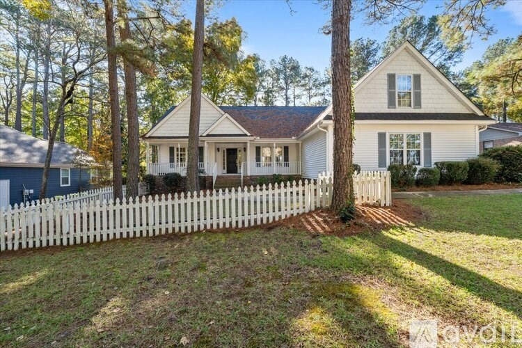 A white house with a blue door and a white picket fence.