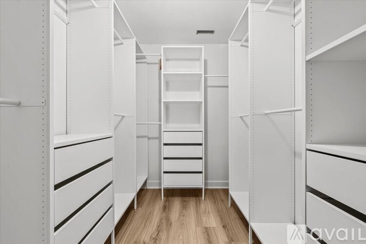 A white walk-in closet with shelves and a ladder.