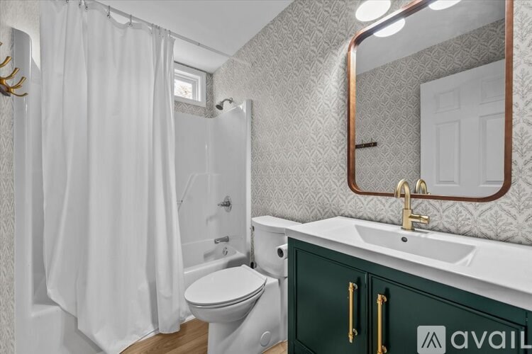 A bathroom with a white toilet, a sink, and a mirror.