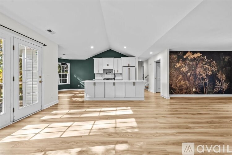 A spacious kitchen with white cabinets and a large island in the middle of the room.