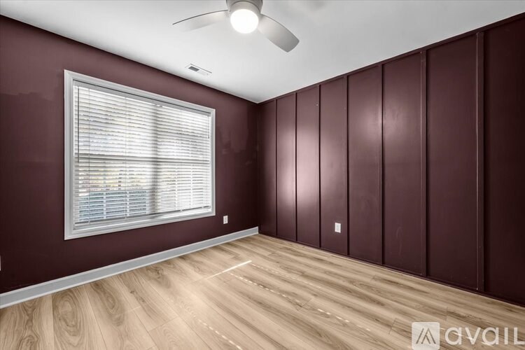 A room with a window and wooden flooring.