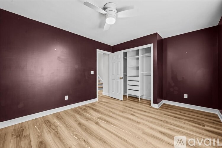 A room with a ceiling fan and a doorway leading to another room.