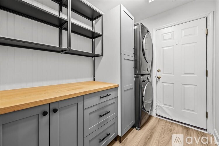 A kitchen with grey cabinets and a white door.