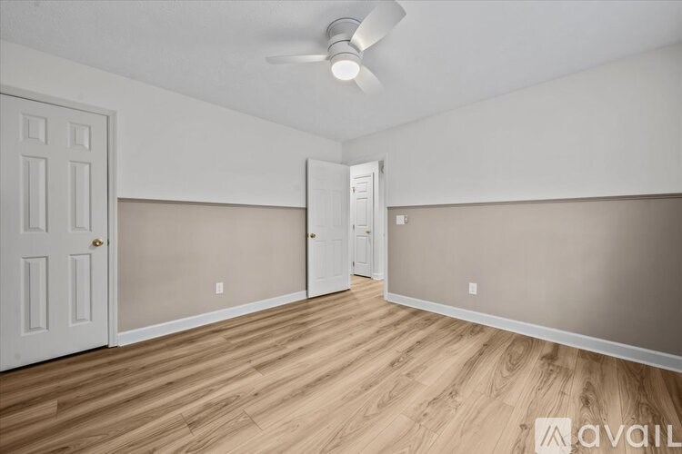 A room with wooden floors and a white ceiling fan.
