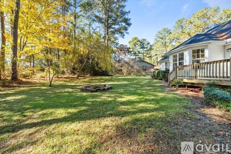A house with a yard and trees in the background.