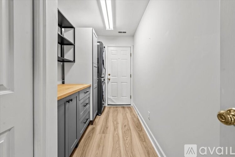 A kitchen with a white door and a white wall.