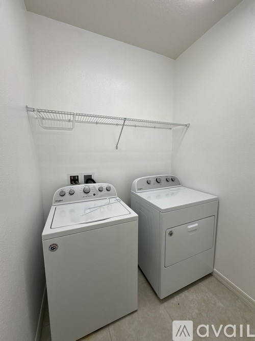 Two white front loading washing machines in a laundry room.