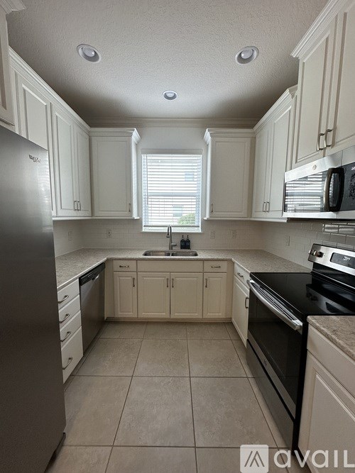 A kitchen with white cabinets and a black stove top oven.