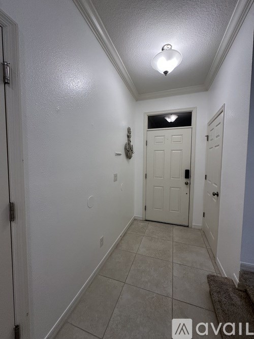 A hallway with a white door and a light on the ceiling.