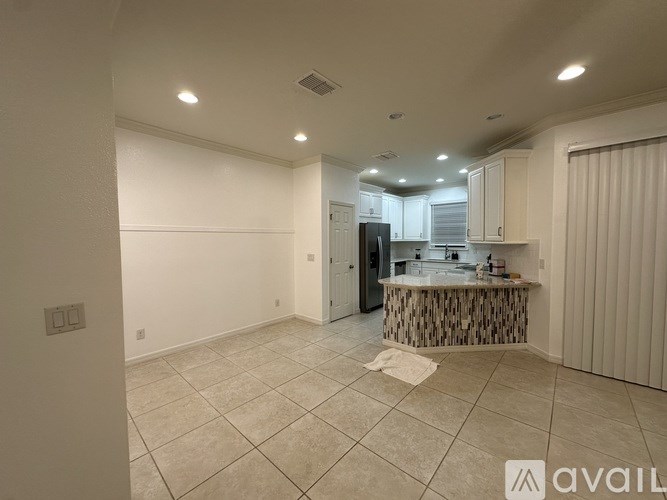 A spacious kitchen with a bar area and a refrigerator.
