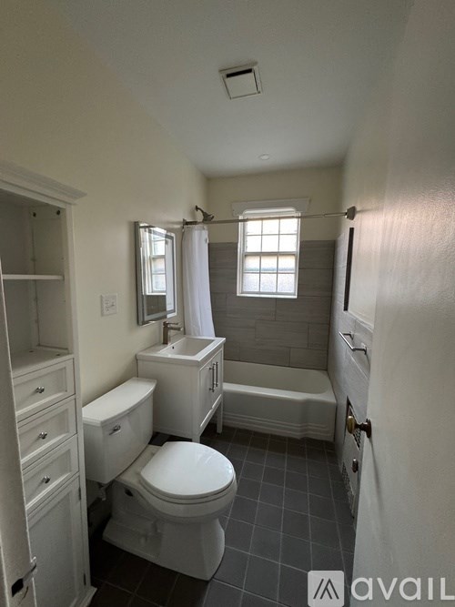 A bathroom with a toilet, sink, and bathtub.