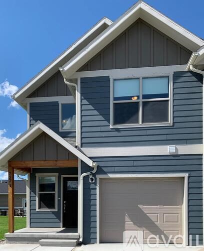 A blue house with a white garage door.