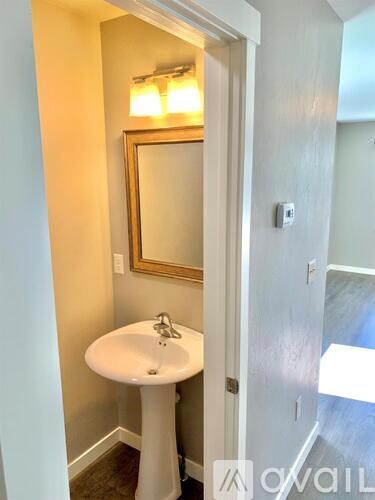 A white pedestal sink with a mirror above it.