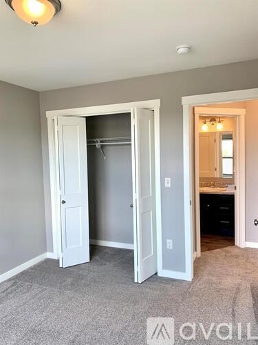 A room with a white door and a carpeted floor.