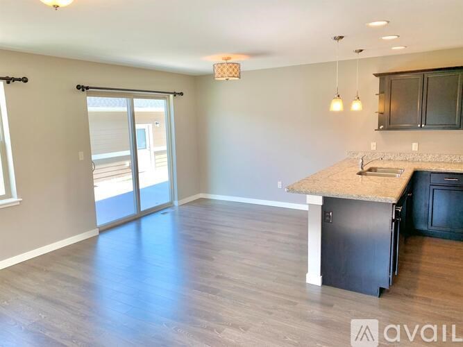 A kitchen with a granite countertop and a sliding glass door leading to a balcony.