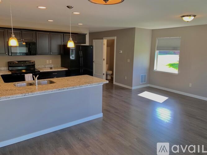 A kitchen with black appliances and a granite countertop.