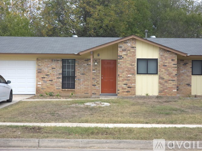 A small house with a red door and a white garage door.