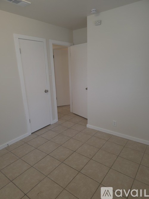 A room with a tiled floor and two doors.