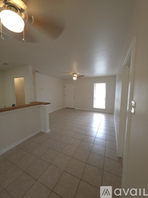 A room with a ceiling fan and tiled floor.