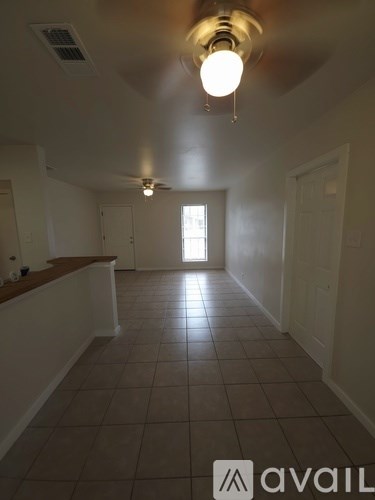 A room with tiled flooring and a window in the middle.