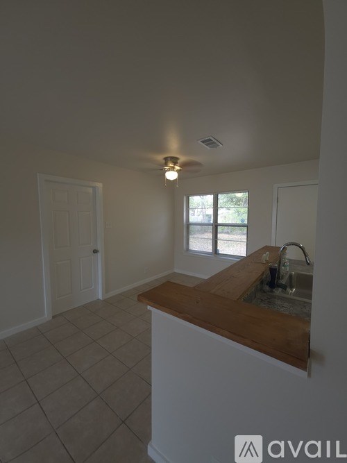 A kitchen with a wooden counter top and a window.