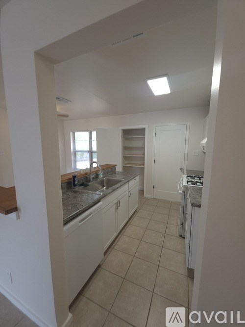 A kitchen with white cabinets and a granite countertop.