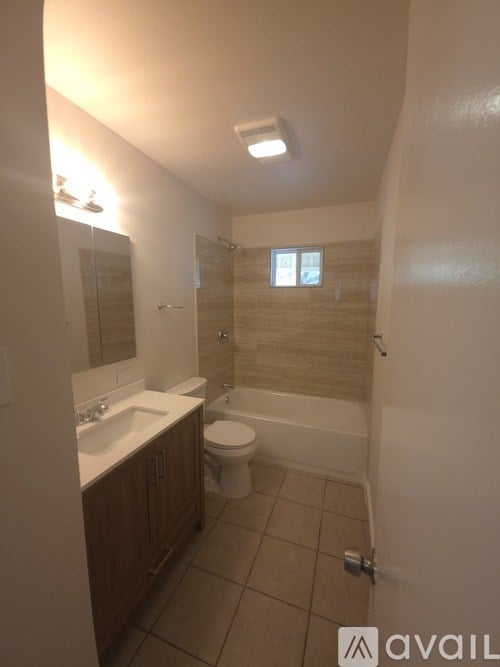 A bathroom with a toilet, sink, and bathtub.