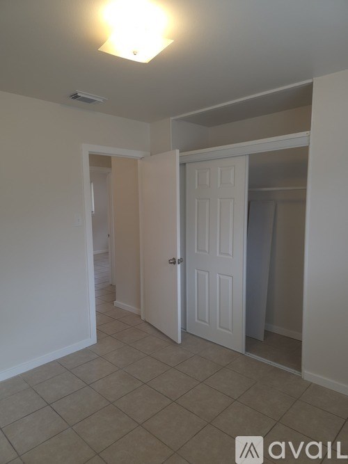 A room with a white door and a tiled floor.