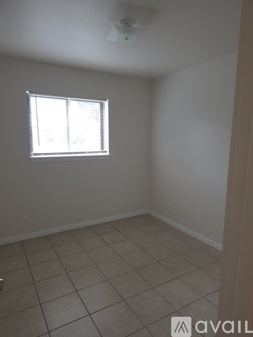 A room with a window and tiled floor.