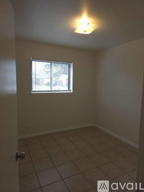 A room with a window and tiled floor.