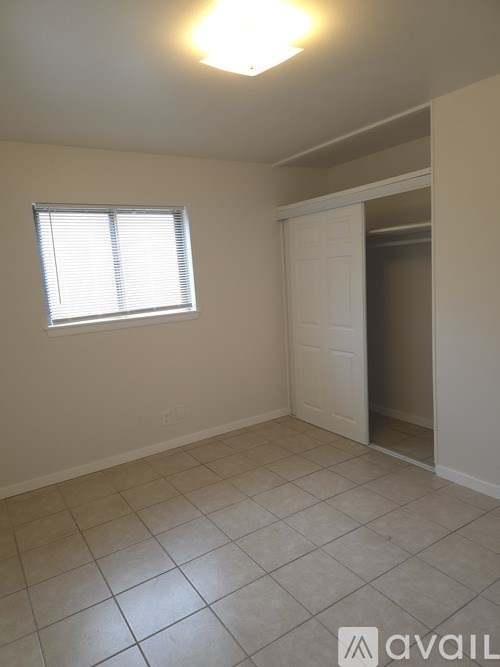 A room with a white door and a window with blinds.