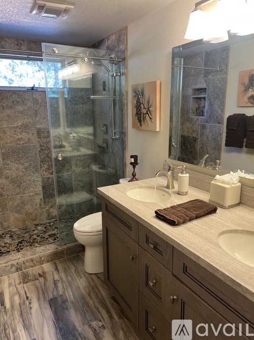 A bathroom with a toilet, sink, and shower.