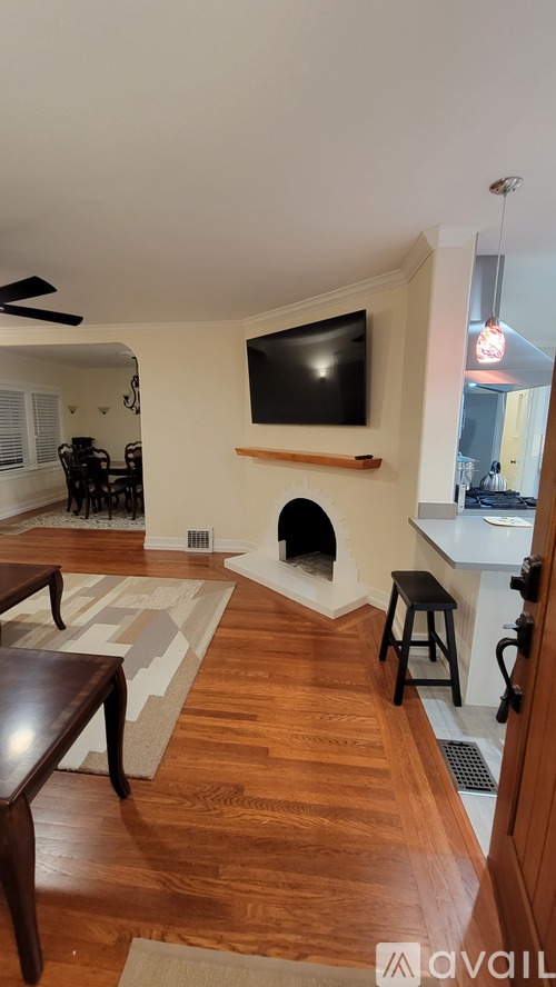 A living room with a flat screen TV mounted on the wall.