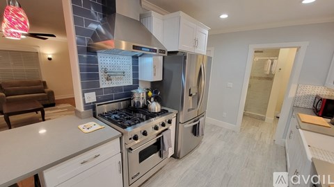 A modern kitchen with a stove top oven and a refrigerator.