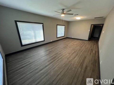 A room with wooden flooring and a ceiling fan.