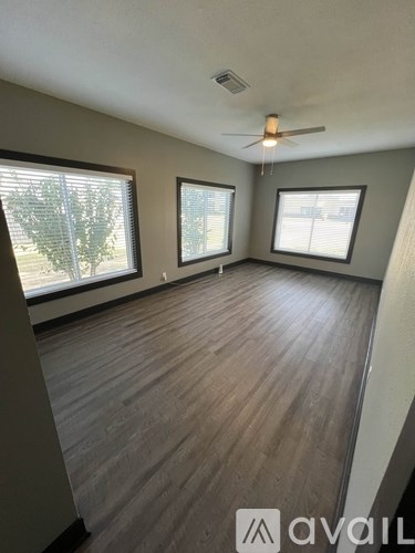 A room with wooden flooring and a ceiling fan.