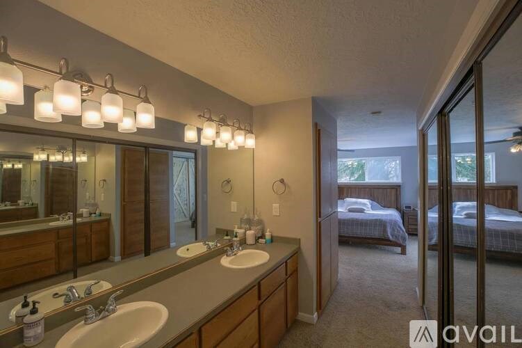 A bathroom with two sinks and a large mirror.