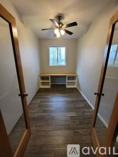 A room with a ceiling fan and a window.