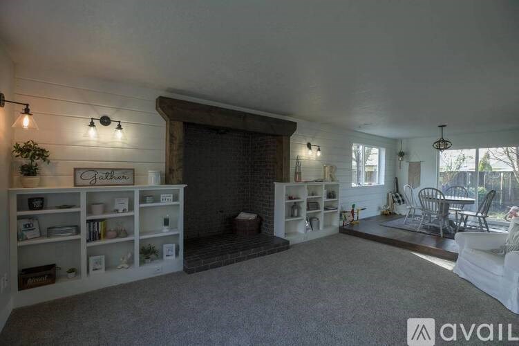 A living room with a fireplace and a dining area.