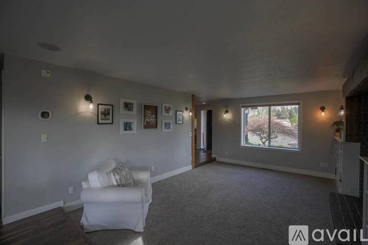 A living room with a white couch and pictures on the wall.