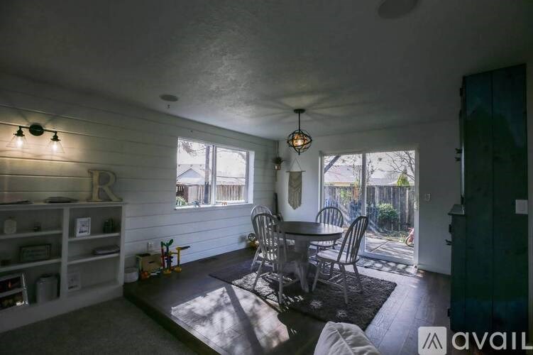 A sunny day in a room with a table and chairs.