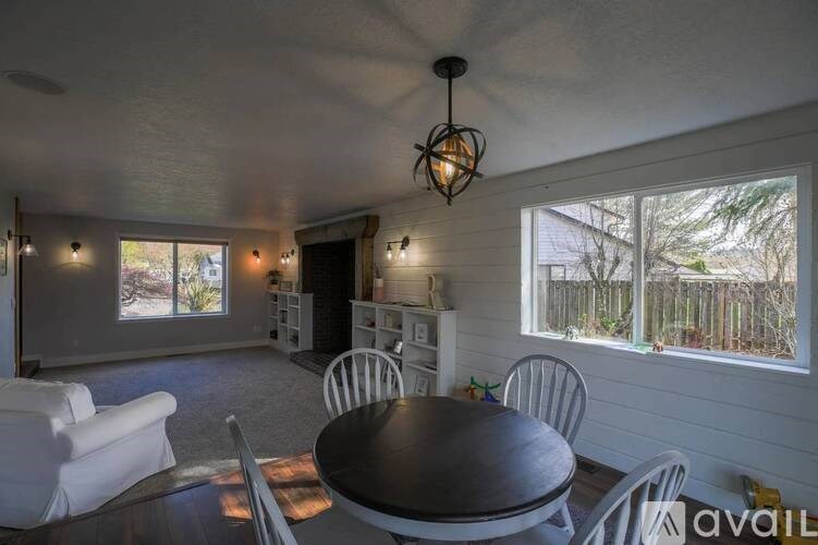 A dining room with a table and chairs.