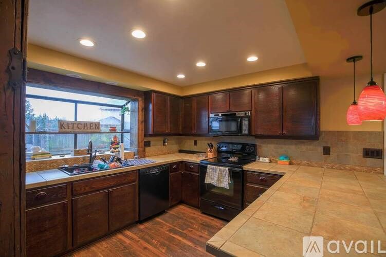 A kitchen with dark wood cabinets and a black oven.