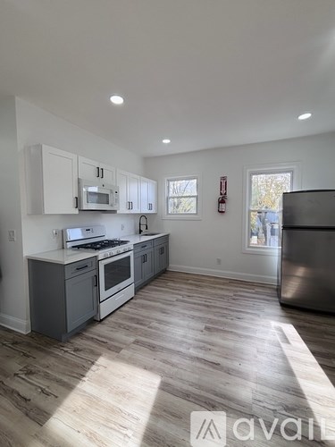 A kitchen with wooden floors and white cabinets.