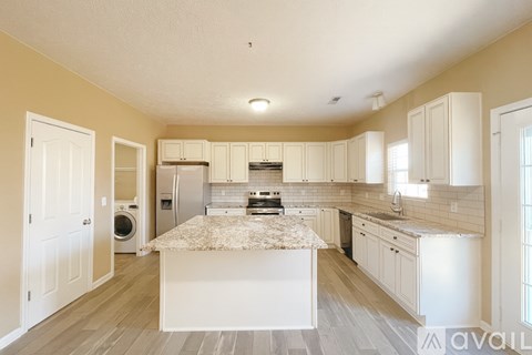 A kitchen with a marble countertop and white cabinets.